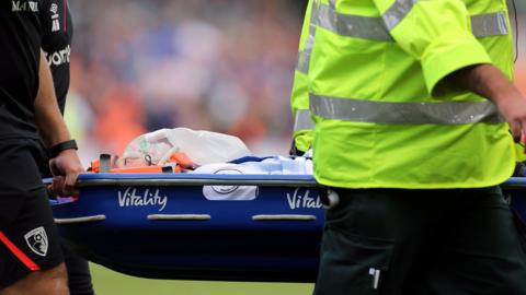 Michael Keane is taken off on a stretcher