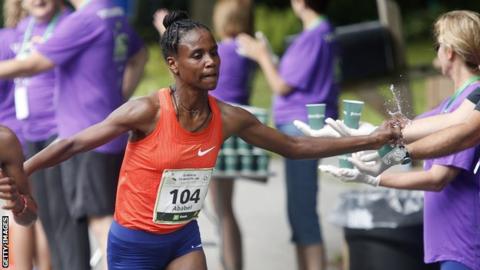 Ababel Yeshaneh trying to grab water while competing in a race
