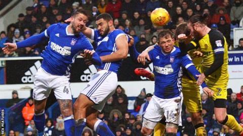 Ipswich and Burton players compete for a header