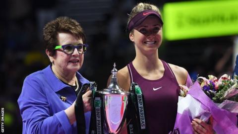 Elina Svitola is presented with the trophy by Billie Jean King