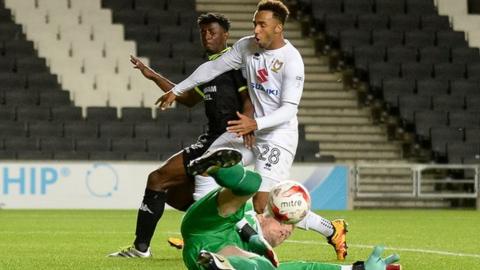 Bury goalkeeper Ben Williams saves from MK Dons striker Nicky Maynard