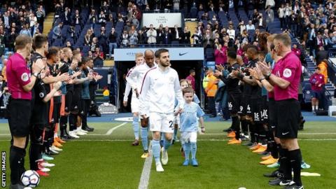 Manchester City players walk out to a guard of honour