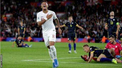 Jadon Sancho celebrates scoring for England