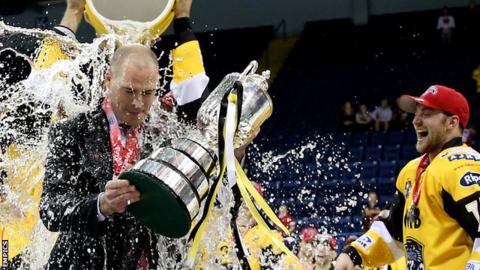 Corey Neilson has water thrown on him as he picks up the Elite League play-off trophy