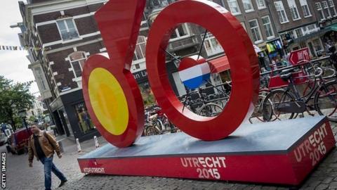 A man walks past a giant imitation bicycle, painted red, as Utrecht prepares to host the Tour de France