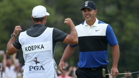 Ricky Elliott is about to embrace Brooks Koepka after the American holed the winning putt at Bethpage on Sunday