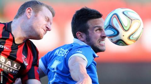 David Magowan of Crusaders in action against Linfield striker Andrew Waterworth