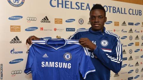 Bertrand Traore holding a Chelsea shirt after signing in 2014