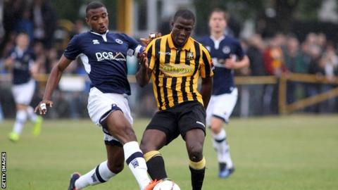 Christian Mbulu tackles Folkestone Invicta's Ade Yussuf while playing for a Millwall XI