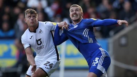 Swansea City's Jake Bidwell (L) and Cardiff City's Danny Ward