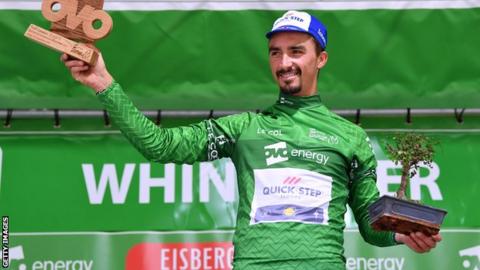 Julian Alaphilippe on the podium in the leader's green jersey