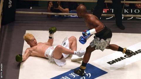 Japanese kickboxer Tenshin Nasukawa (left) is floored by former world champion boxer Floyd Mayweather (right) in an exhibition boxing match in Tokyo