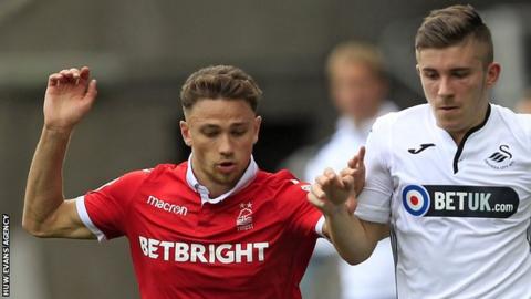 Declan John of Swansea City (R) takes on Matty Cash