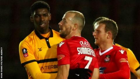 Tyreeq Bakinson of Newport County and Luke Summerfield of Wrexham have a disagreement