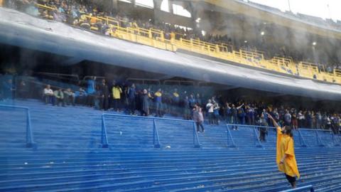 Fans shelter from the rain at Boca's La Bombonera stadium
