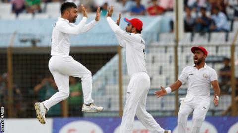 Afghanistan cricketer Rashid Khan celebrates with his teammates