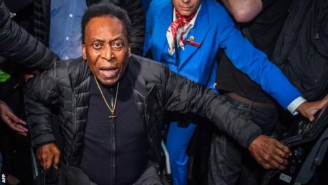 Pele being helped out of a wheelchair in 2019