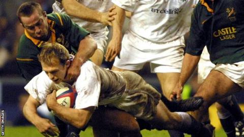 Matt Dawson is tackled by South Africa's Corne Krige