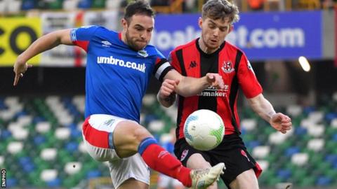 Linfield midfielder Jamie Mulgrew battles with Crues forward Jamie McGonigle for the ball