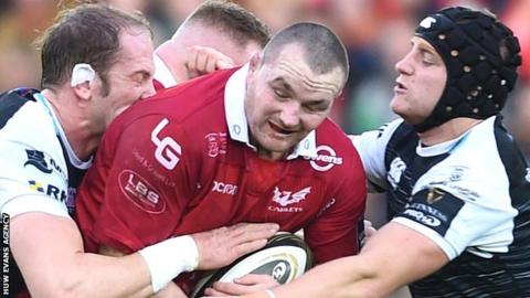 Ospreys Alun Wyn Jones (L) and James King tackle Ken Owens