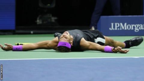 Rafael Nadal lies on the ground in celebration