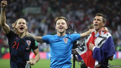 Croatia players Domagoj Vida (L), Ivan Rakitic and Mario Mandzukic (R) celebrate reaching the World Cup final