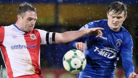 Linfield skipper Jamie Mulgrew in action against Paul McElroy of Dungannon Swifts