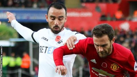 Leon Britton of Swansea City challenges Manchester United's Juan Mata