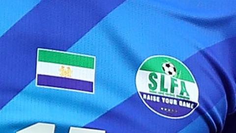 The Sierra Leone Football Association logo and Sierra Leone flag