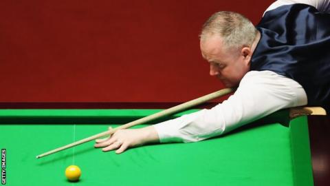John Higgins plays a shot