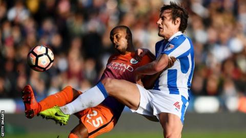 Man City's Fernandinho and Huddersfield's Dean Whitehead challenge for the ball