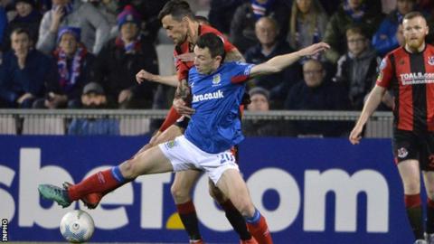 Crues midfielder Declan Caddell and Linfield's Stephen Fallon tussle for the ball