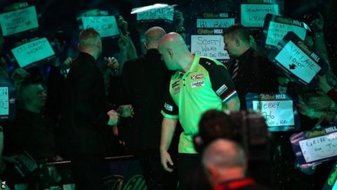 Michael van Gerwen turns to face the crowd after he was soaked in beer at Alexandra Palace