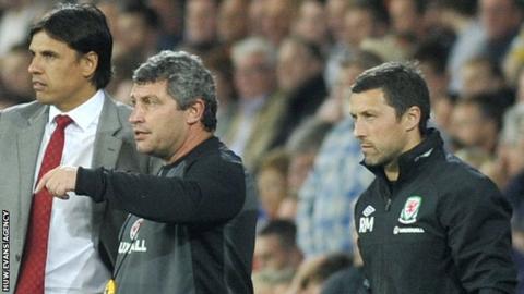 Ryland Morgans (R) watches Wales in 2014 alongside then manager Chris Coleman and assistant Osian Roberts