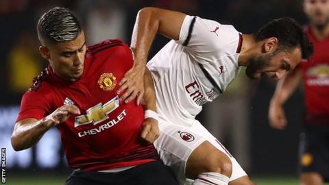 Hakan Calhanoglu of AC Milan and Andreas Pereira contest for the ball in Carson, California in July, 2018