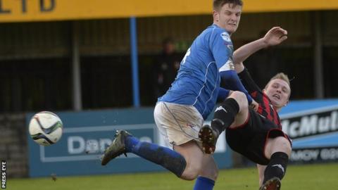 Dungannon's Dougie Wilson gets in a tangle with Crusaders striker Jordan Owens