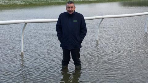 Chepstow Racecourse chief executive Phil Bell stands knee deep in water at the course on 27 December, 2017