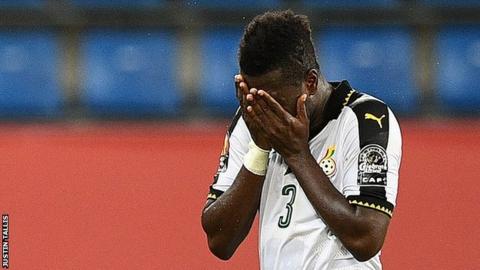 Ghana captain Asamoah Gyan holds his head in his hands as he leaves the pitch because of an injury