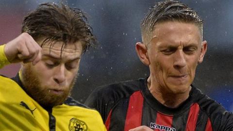 Cliftonville's James Knowles in action against Matthew Snoddy of Crusaders