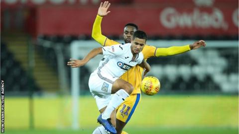 Kyle Naughton of Swansea City wins the ball from Gavin Massey of Wigan Athletic