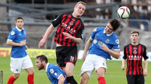 Jordan Owens of Crusaders and Linfield's Jimmy Callacher in aerial action