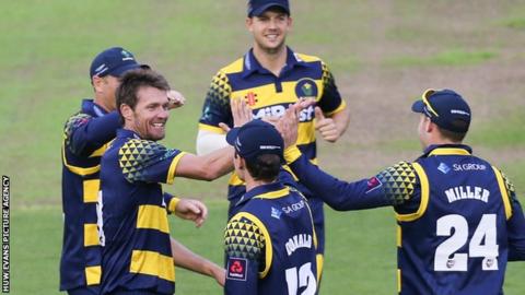 Glamorgan bowler Michael Hogan (L) celebrates a wicket with David Miller