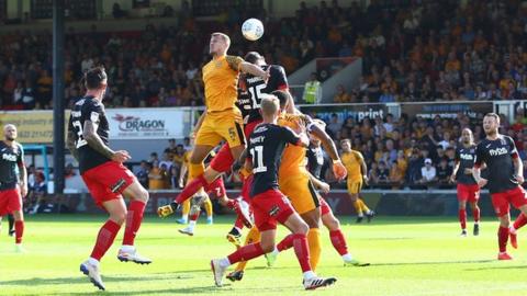 Kyle Howkins of Newport County wins a high ball