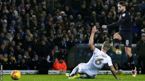 Henri Lansbury scores for Aston Villa as Leeds United's Liam Cooper tries to make the block