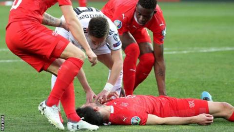 Georgian player Jano Ananidze tries to help Fabian Schar during the Euro 2020 qualifier