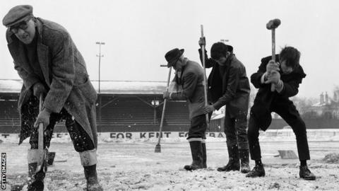 Workers in 1963 try and clear of football pitch full of snow