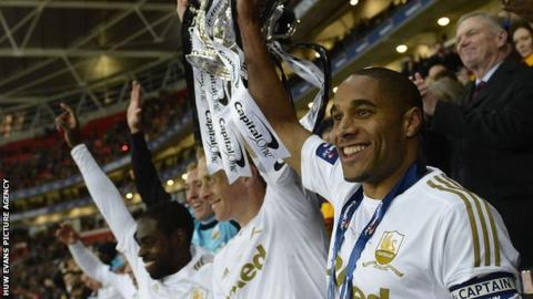 Ashley Williams (right) and Garry Monk (centre) lift the League Cup trophy