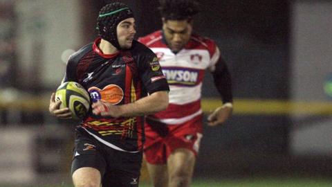 Dragons player Adam Hughes scoring a try against Gloucester