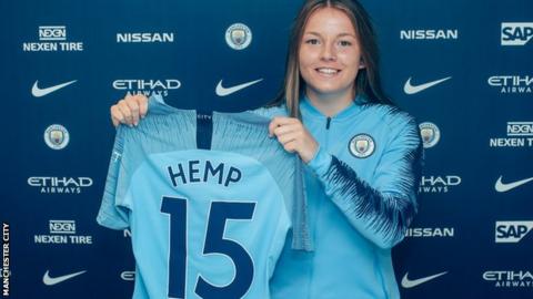 Lauren Hemp holds up a Manchester City shirt after her unveiling