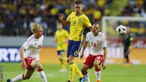 Sweden's Mikael Lustig competes for the ball against Denmark's Martin Braithwaite and Kasper Dolberg